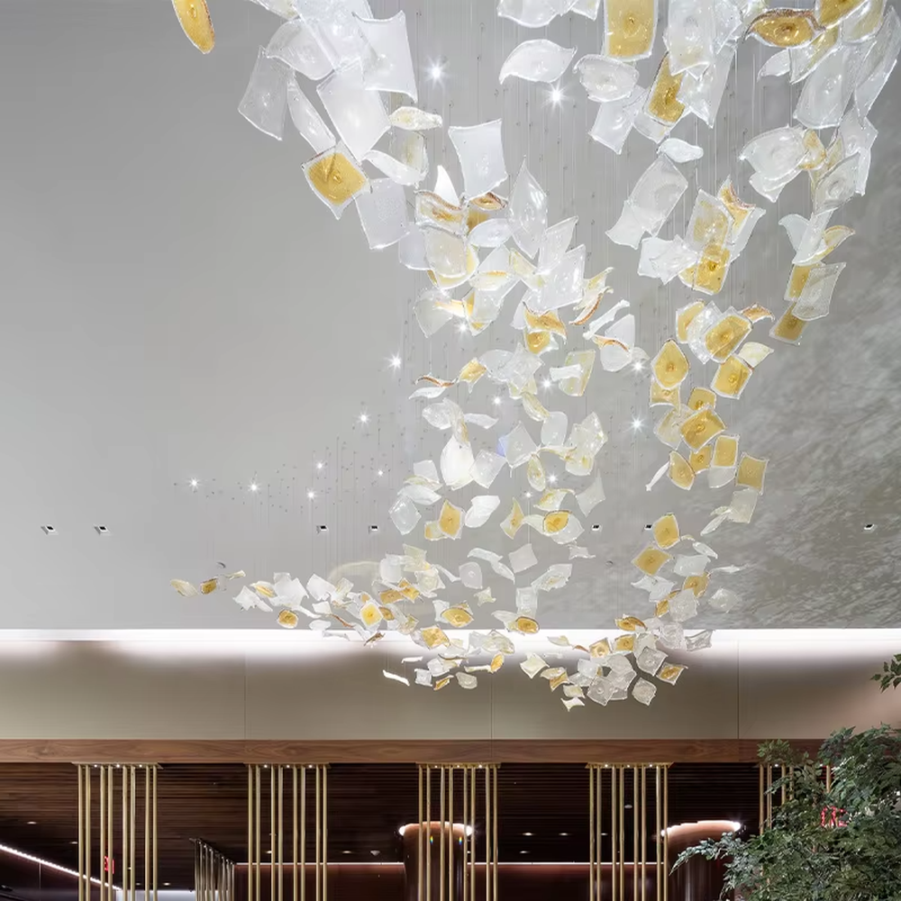 This is an artistic installation-style glass piece chandelier, with numerous transparent and golden glass pieces hanging in a scattered manner, featuring strong artistic sense, and the light reflects a brilliant visual effect. It is used for space lighting and artistic decoration, creating a luxurious artistic atmosphere. Suitable for high-end hotel lobbies, art exhibition halls, luxury shopping mall atriums and other places.