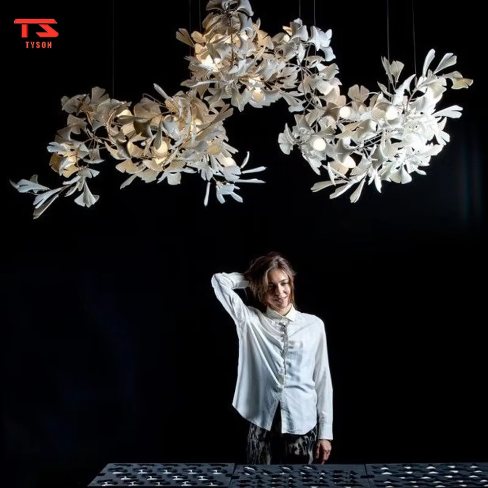 This is an artistic natural-style spiral ginkgo leaf decorative chandelier, with a golden spiral frame paired with white and golden ginkgo leaf-shaped decorations. The design combines artistic sense and natural charm, being luxurious and exquisite, with soft and elegant lighting. It is used for space lighting and artistic decoration, creating an artistic and natural luxurious atmosphere. Suitable for high-ceiling stairwells of high-end hotels, luxury villa living rooms, art exhibition halls and other places.
