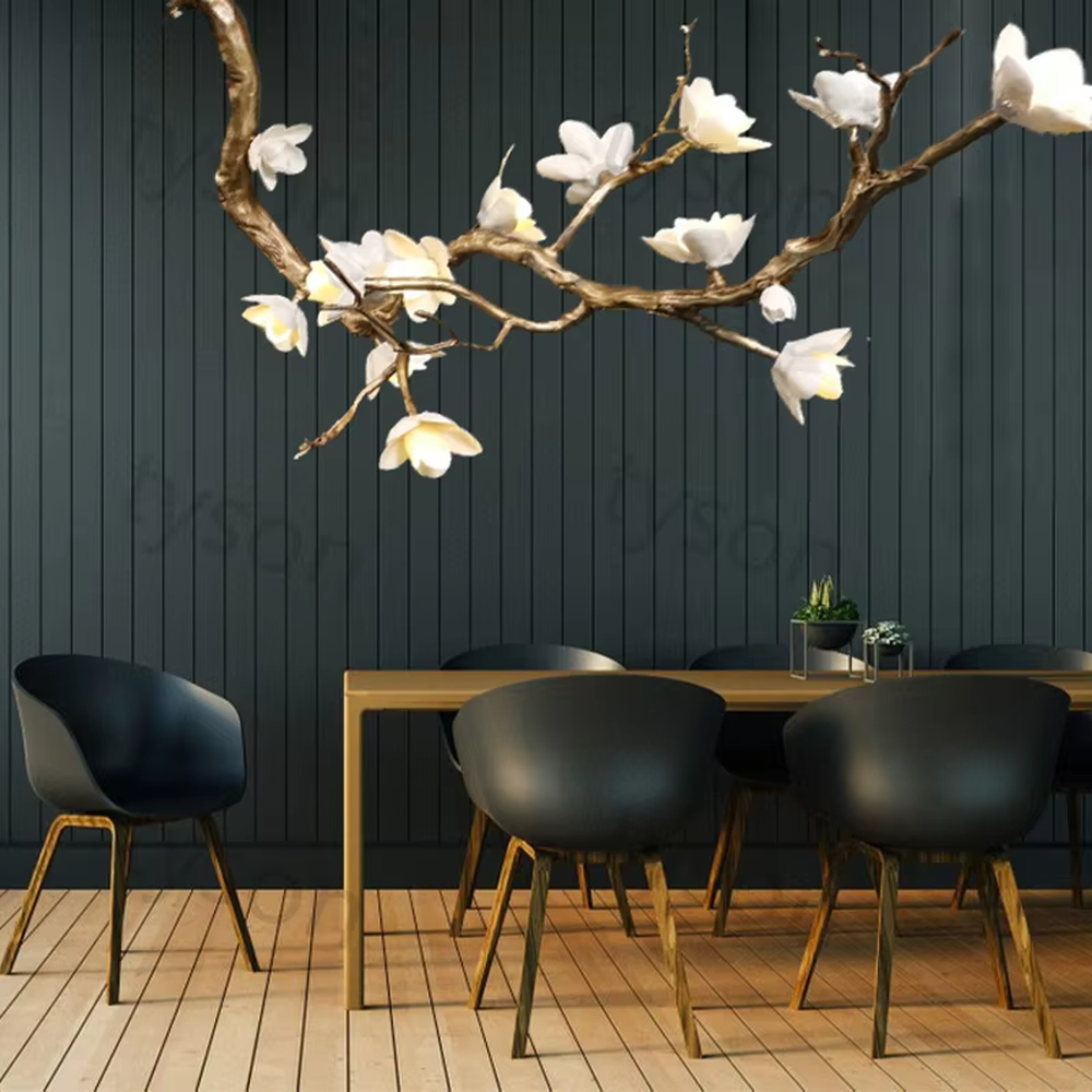 This is an artistic luxurious magnolia branch-shaped chandelier, with a golden simulated branch frame paired with white magnolia-shaped lampshades. The design combines natural artistic sense and luxurious texture, with soft and elegant lighting. It is used for space lighting and artistic decoration to create an artistic luxurious atmosphere. Suitable for light luxury-style dining rooms, luxury villa living rooms, high-end hotel banquet halls and other places.