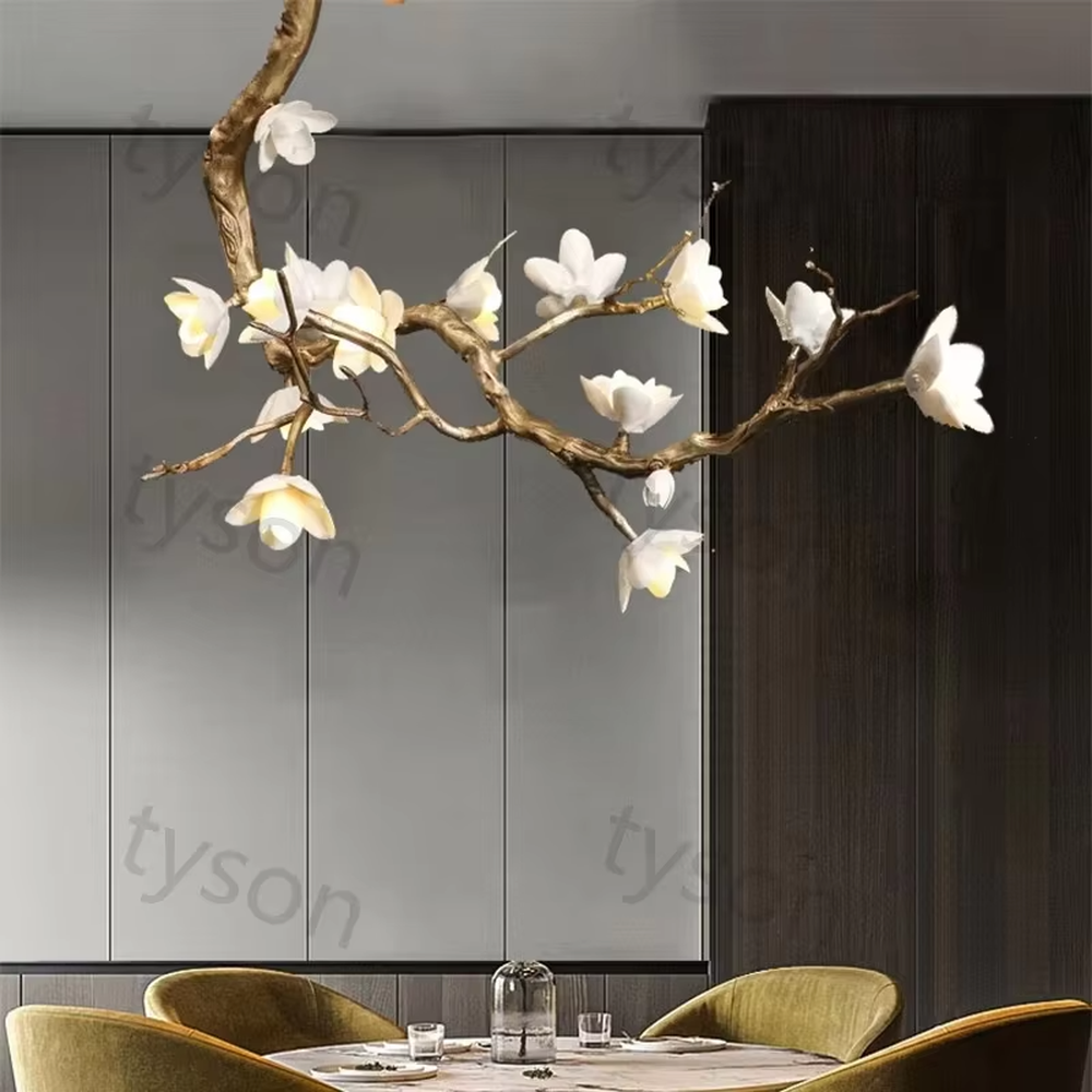 This is an artistic luxurious magnolia branch-shaped chandelier, with a golden simulated branch frame paired with white magnolia-shaped lampshades. The design combines natural artistic sense and luxurious texture, with soft and elegant lighting. It is used for space lighting and artistic decoration to create an artistic luxurious atmosphere. Suitable for light luxury-style dining rooms, luxury villa living rooms, high-end hotel banquet halls and other places.