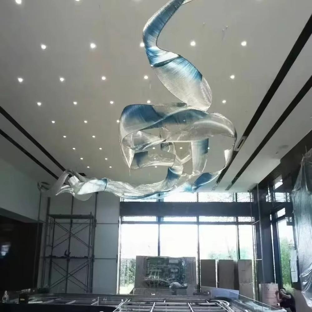 This is an artistic streamline chandelier with a flowing ribbon shape in blue and white gradient, featuring great dynamism and artistry. It is used for space lighting and artistic decoration, significantly enhancing the artistic atmosphere and visual impact of the space. It is suitable for high-end hotel lobbies, art galleries, atriums of large commercial spaces and other places.
