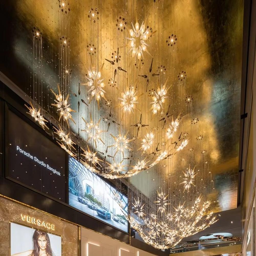 This is an artistic radial flower-shaped glass chandelier, with multi-layer colored glass components (gold, transparent, etc.) in a radial flower design, hanging structure, featuring strong artistic sense and visual hierarchy. It is used for space lighting and artistic decoration, creating a luxurious artistic atmosphere. It is suitable for high-end hotel lobbies, art exhibition halls, luxury clubs and other places.