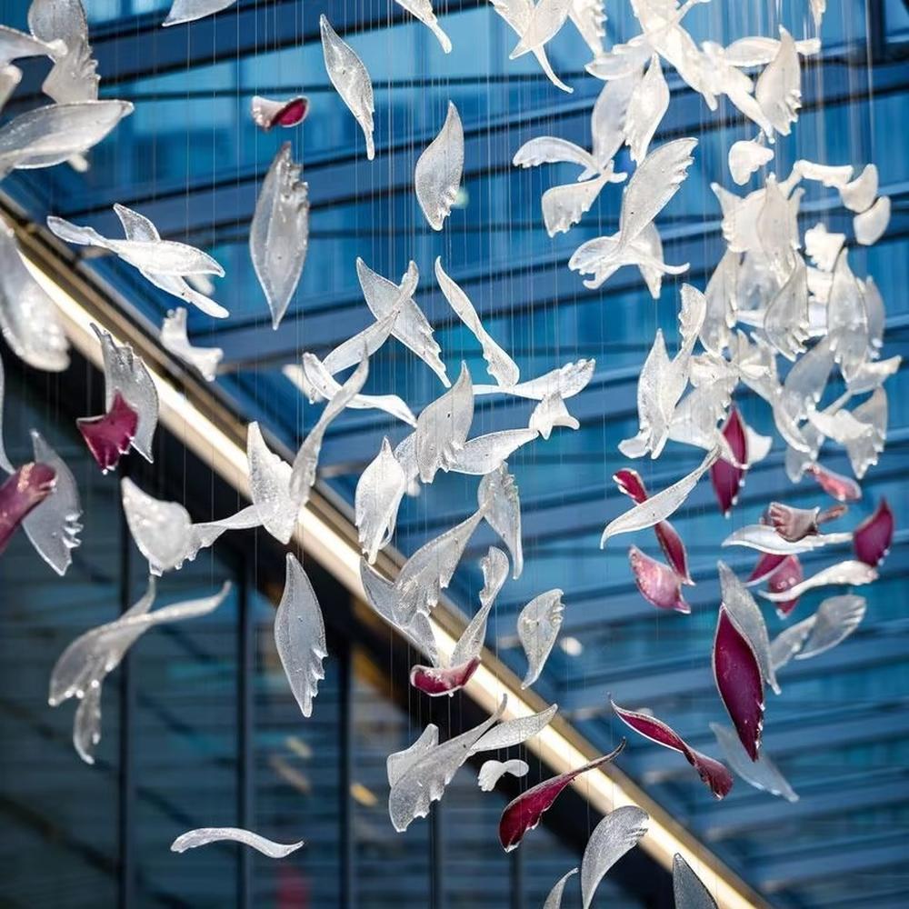 This is a modern artistic bird-shaped chandelier, composed of numerous white and pink bird-like elements hanging together. It features a highly artistic and visually striking design, with a dynamic beauty like a flock of birds flying. It is used for space lighting and artistic decoration, capable of creating a creative visual focus and enhancing the artistic atmosphere of the space. It is suitable for atriums of high-end commercial centers, modern art galleries, lobbies of luxury hotels and other places.