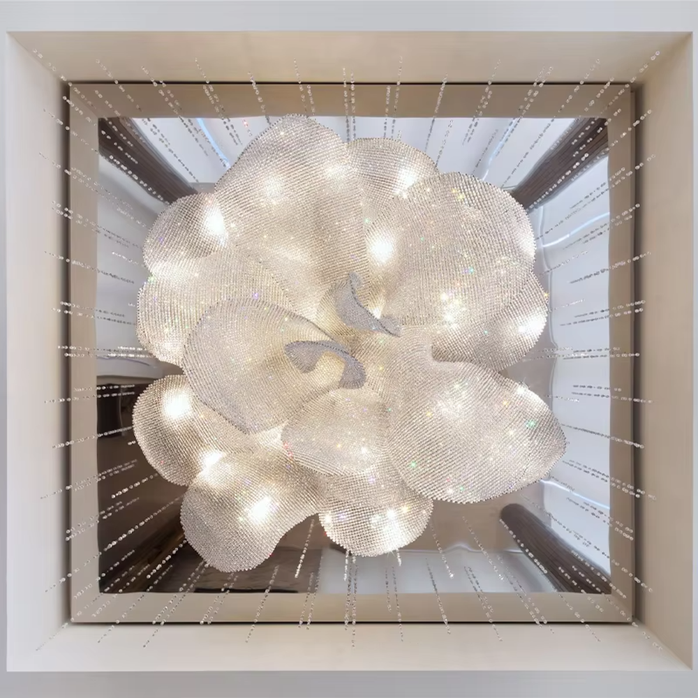 This is a luxurious artistic crystal petal-shaped chandelier, crafted with white crystals in a blooming flower shape. When lit, the light is brilliant and gorgeous, creating a high-end luxurious space atmosphere.