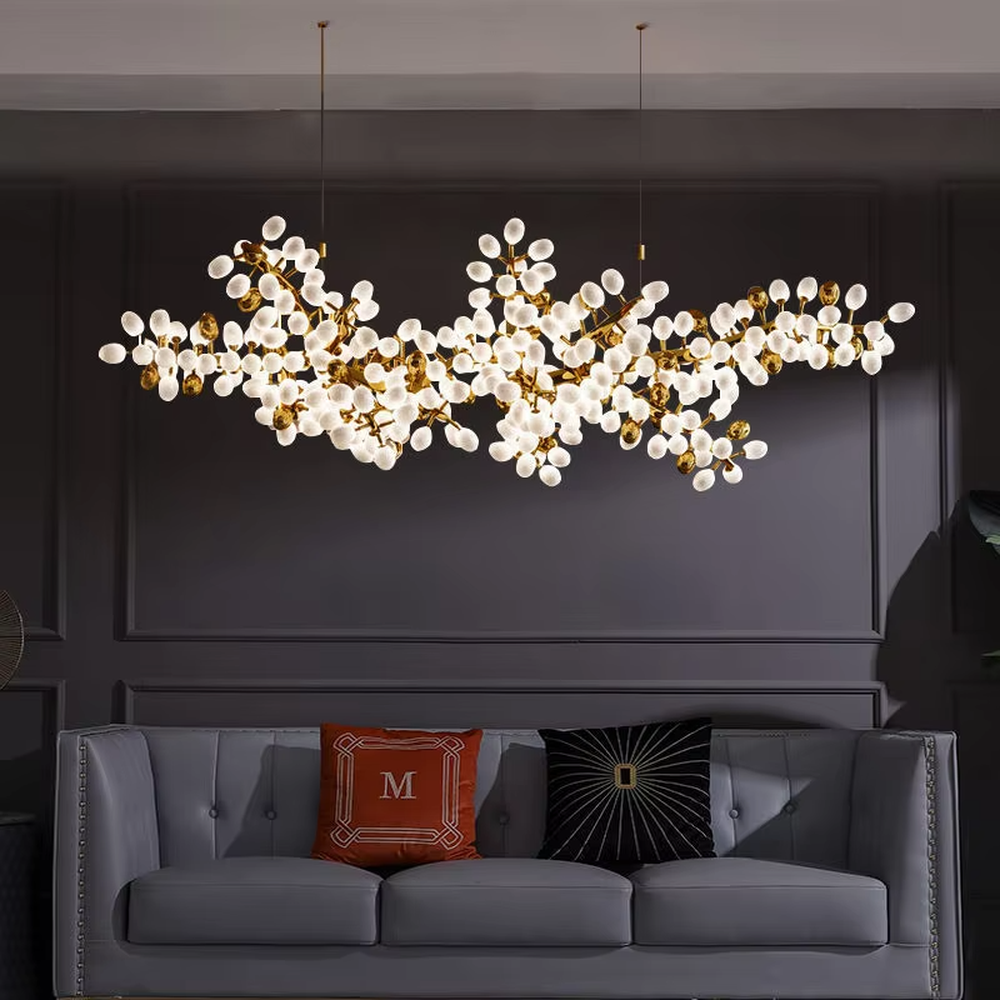 This is a light luxury artistic long strip flower branch-shaped chandelier, with golden metal branches paired with a large number of white spherical lampshades. The shape is like blooming flower branches, with soft and brilliant lighting, creating a light luxury artistic atmosphere.