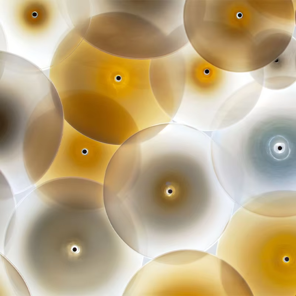 This is a modern artistic multi-layer disc glass art chandelier, composed of numerous gradient gold and white disc glass elements hanging in layers to form a three-dimensional ceiling decorative shape. It features soft and artistically layered lighting, with a strong sense of modern art and spatial decorativeness. It is used for space lighting and artistic installation decoration, creating a modern artistic and high-end elegant atmosphere. Suitable for high-end hotel lobby corridors, art exhibition halls, luxury commercial spaces and other places.