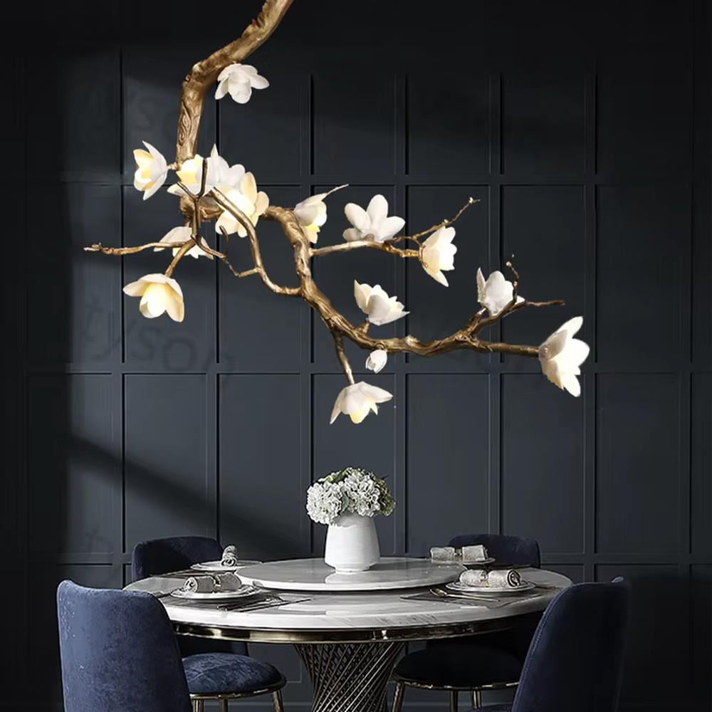 This is an artistic luxurious magnolia branch-shaped chandelier, with a golden simulated branch frame paired with white magnolia-shaped lampshades. The design combines natural artistic sense and luxurious texture, with soft and elegant lighting. It is used for space lighting and artistic decoration to create an artistic luxurious atmosphere. Suitable for light luxury-style dining rooms, luxury villa living rooms, high-end hotel banquet halls and other places.