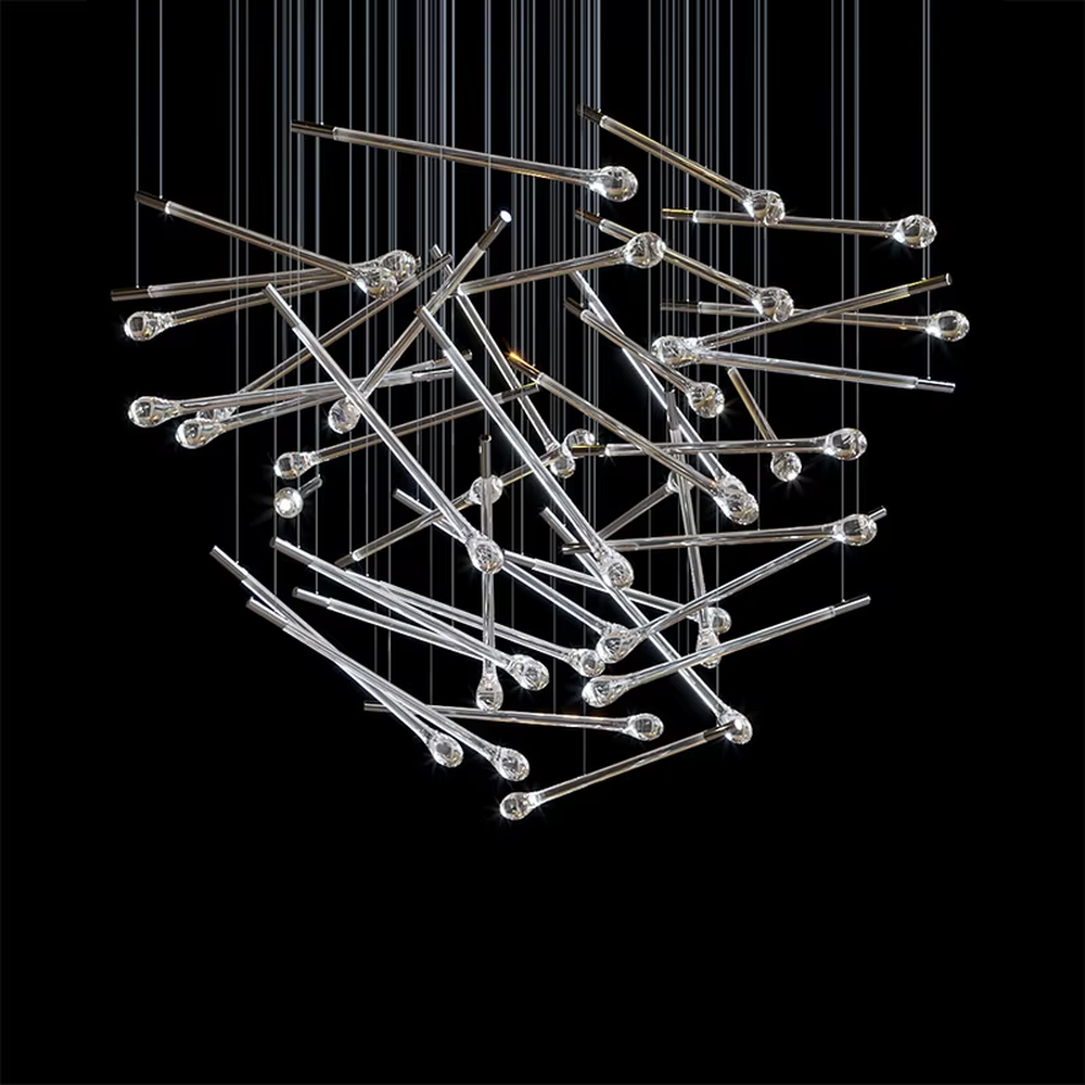 This is a modern artistic transparent crystal rod staggered hanging chandelier, with silver metal slender rods paired with crystal ends, multiple rods staggered and hung. When the lights are on, it is brilliant and dreamy, creating a highly artistic space atmosphere.
