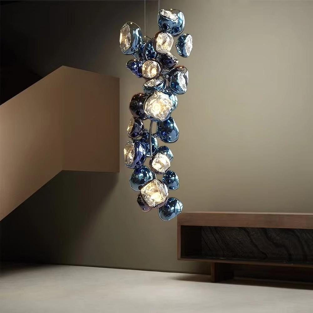 This is an artistic gem-shaped chandelier with blue-black metallic gem-like lampshades distributed in a branch-like structure, featuring a modern artistic design with strong luxury sense. It is used for space lighting and decoration, creating a modern artistic luxury atmosphere. It is suitable for modern luxury home living rooms, high-end commercial exhibition halls, art soft decoration spaces and other places.