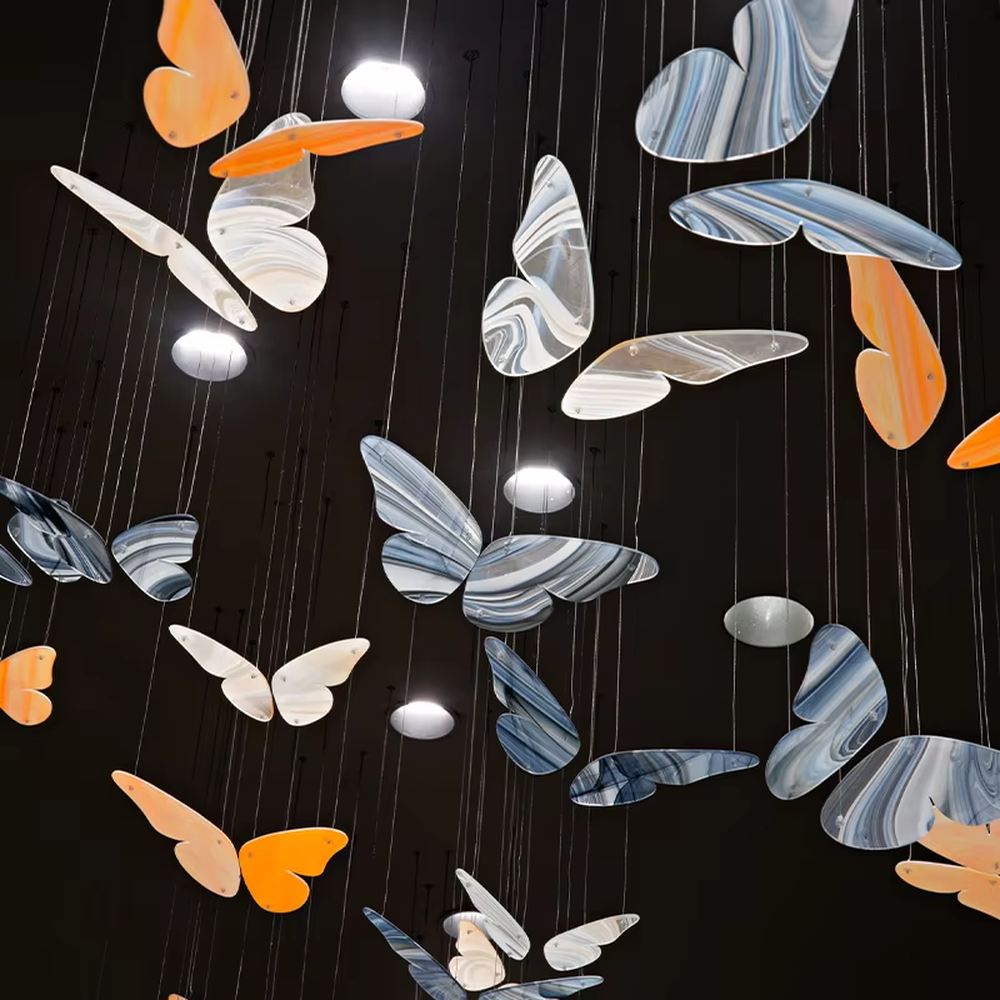 This is an artistic and childlike colorful butterfly-shaped chandelier, with butterfly leaves in various colors (orange, white, blue-gray, etc.) hanging in a scattered manner, featuring strong artistic sense and childlike charm, like a group of butterflies dancing under the light. It is used for space lighting and artistic decoration, creating a lively and artistic atmosphere. Suitable for children's parks, theme restaurants, art exhibition halls and other places.