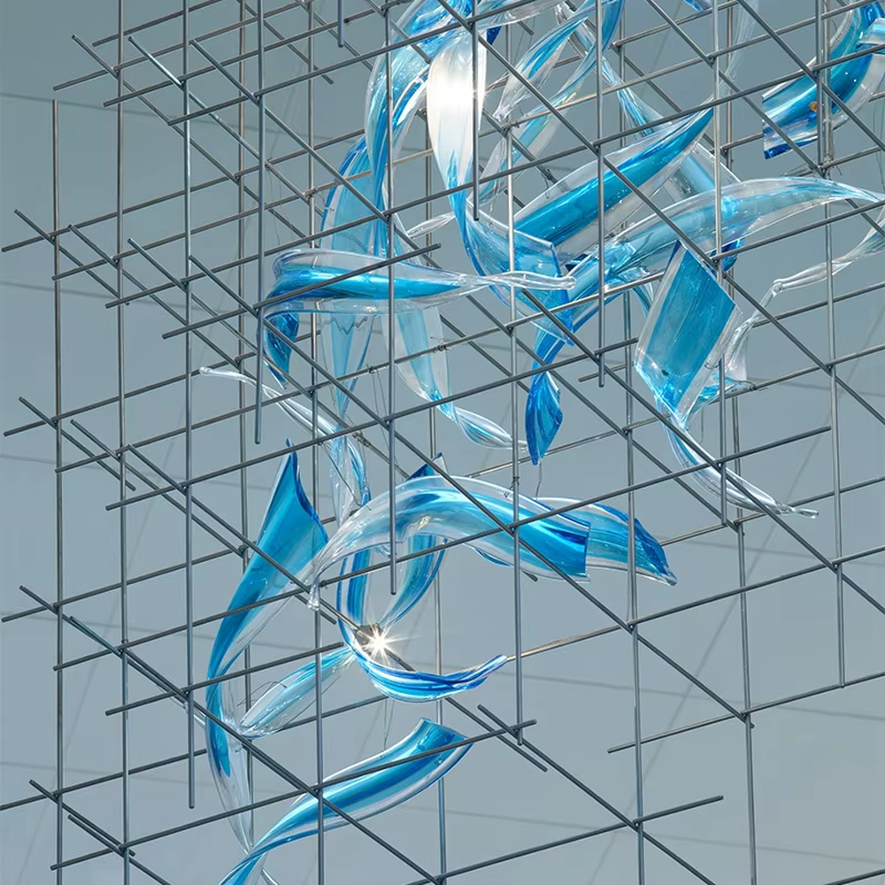 This is a modern artistic metal grid blue transparent decorative chandelier, with a metal grid as the frame, paired with flowing blue transparent shape decorations, and lights dotted in it, creating a dynamic artistic space atmosphere.