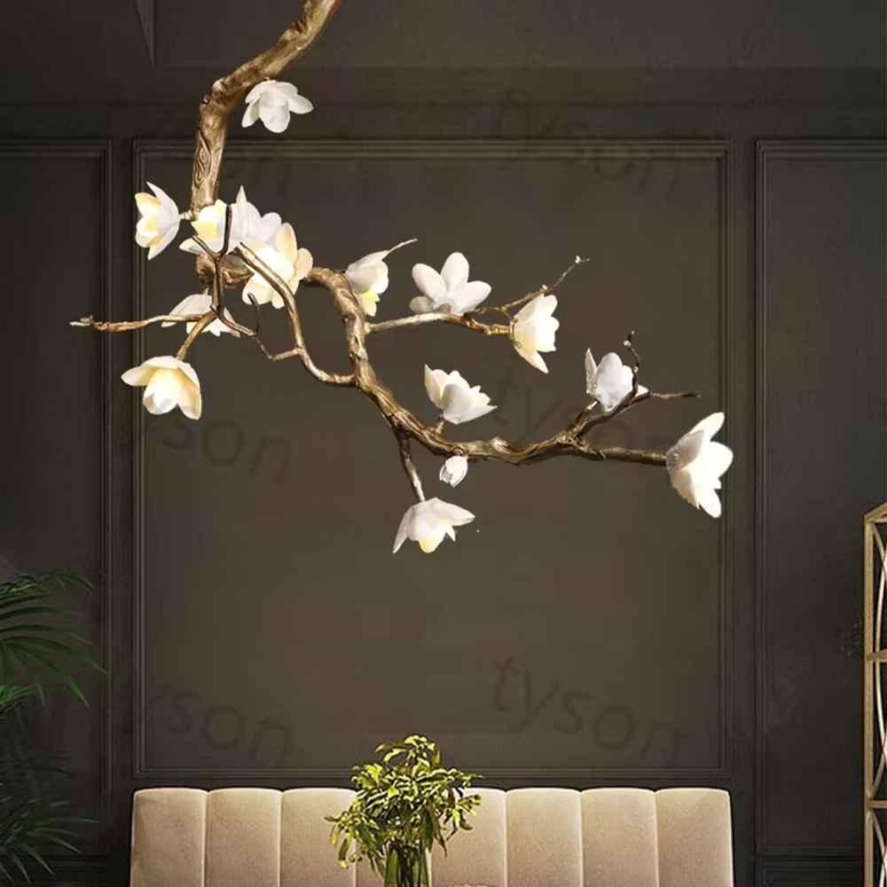 This is an artistic luxurious magnolia branch-shaped chandelier, with a golden simulated branch frame paired with white magnolia-shaped lampshades. The design combines natural artistic sense and luxurious texture, with soft and elegant lighting. It is used for space lighting and artistic decoration to create an artistic luxurious atmosphere. Suitable for light luxury-style dining rooms, luxury villa living rooms, high-end hotel banquet halls and other places.