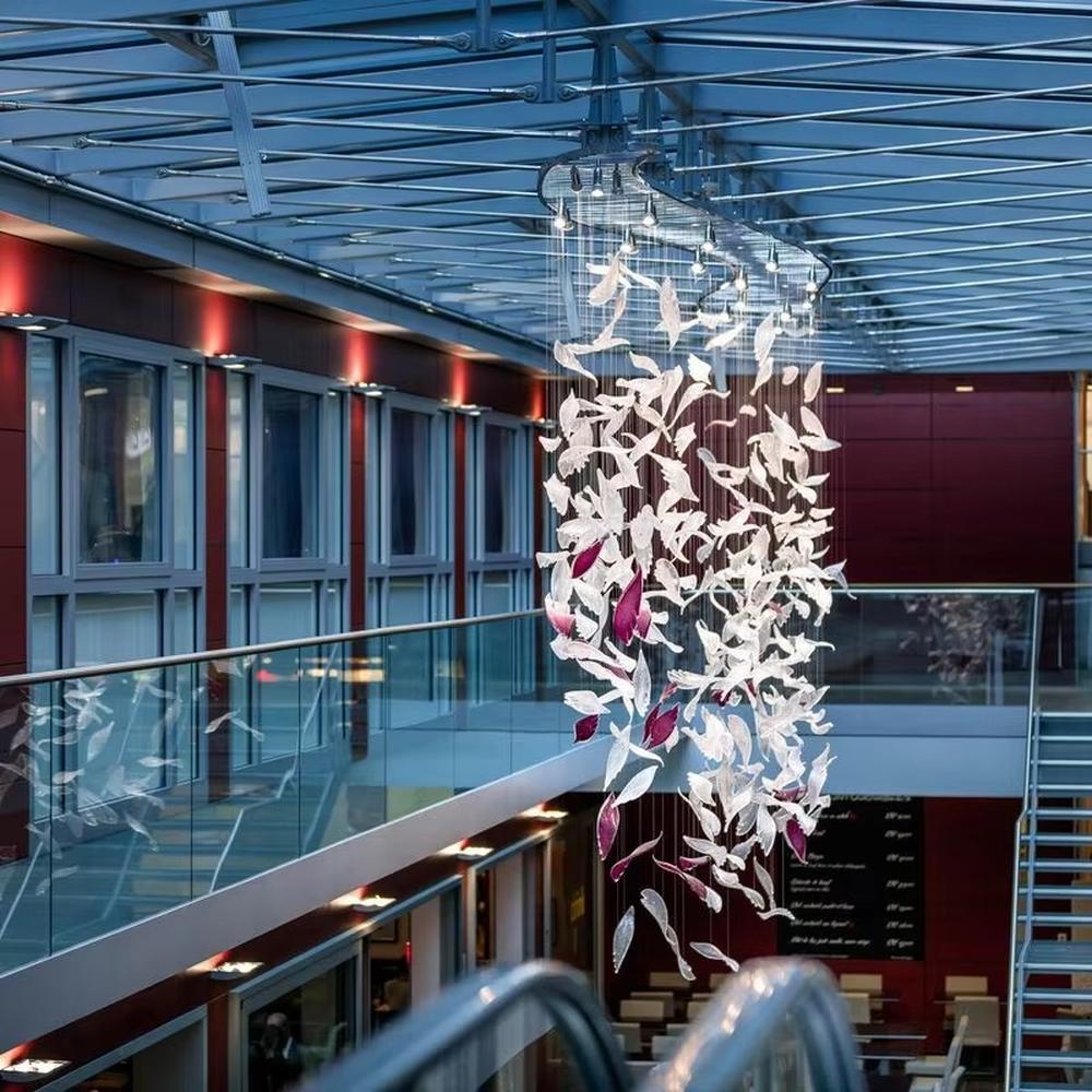 This is a modern artistic bird-shaped chandelier, composed of numerous white and pink bird-like elements hanging together. It features a highly artistic and visually striking design, with a dynamic beauty like a flock of birds flying. It is used for space lighting and artistic decoration, capable of creating a creative visual focus and enhancing the artistic atmosphere of the space. It is suitable for atriums of high-end commercial centers, modern art galleries, lobbies of luxury hotels and other places.