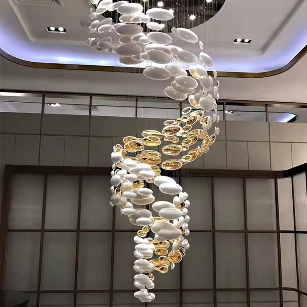 This is an artistic installation-style gold and white spiral glass piece chandelier, with numerous golden and white oval glass pieces hanging in a spiral and scattered manner, featuring strong artistic sense and visual impact, with brilliant light refraction. It is used for space lighting and artistic decoration, creating a luxurious artistic atmosphere. Suitable for high-end hotel lobbies, art exhibition halls, luxury shopping mall atriums and other places.