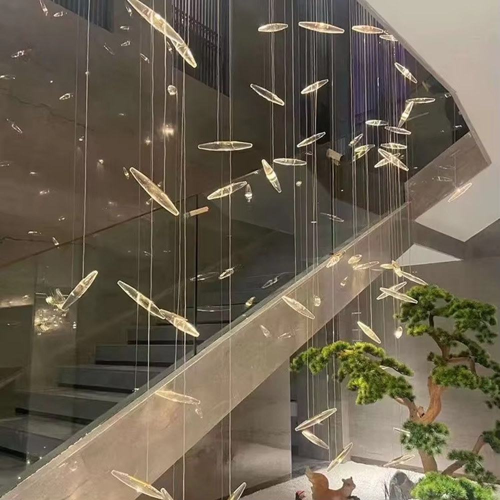 This is a modern artistic fish school-shaped hanging chandelier, featuring multiple silver fish-shaped decorations (crystal/metal texture) suspended by thin wires. The design is dynamic, modern and full of artistic tension, with brilliant and exquisite lighting. It is used for space lighting and artistic decoration, creating a high-end modern artistic atmosphere. Suitable for high-ceiling areas of high-end hotels, luxury commercial clubs, modern art villas and other places.