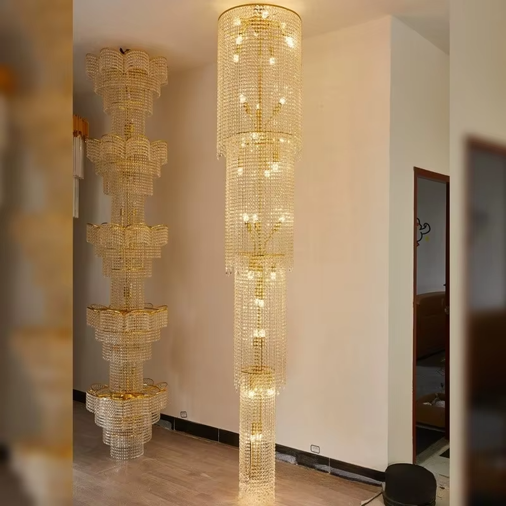 This is a luxury multi-layer cylindrical crystal chandelier, with a golden metal frame and multi-layer transparent crystal pendants, brilliant lighting, featuring a magnificent and grand design with strong visual impact. It is used for space lighting and decoration, creating a high-end luxury atmosphere. It is suitable for duplex stairwells, high-ceilinged living rooms, high-end hotel lobbies and other places.