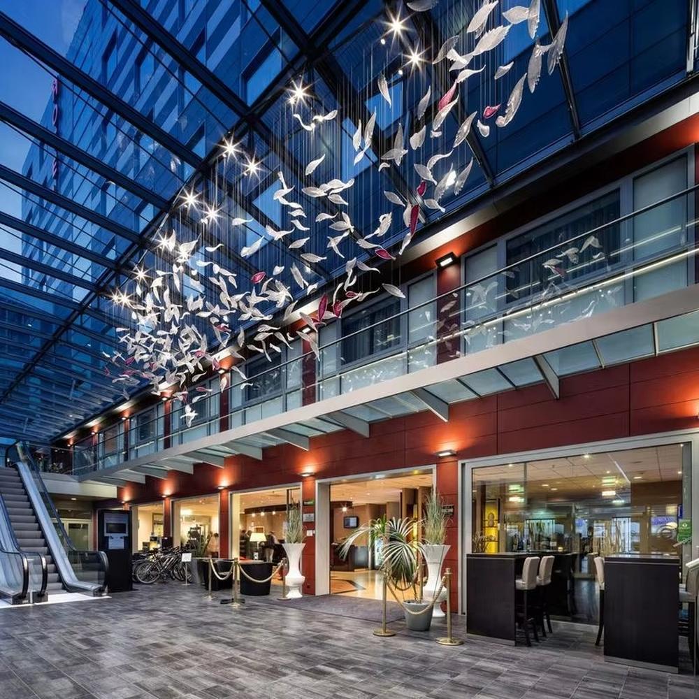 This is a modern artistic bird-shaped chandelier, composed of numerous white and pink bird-like elements hanging together. It features a highly artistic and visually striking design, with a dynamic beauty like a flock of birds flying. It is used for space lighting and artistic decoration, capable of creating a creative visual focus and enhancing the artistic atmosphere of the space. It is suitable for atriums of high-end commercial centers, modern art galleries, lobbies of luxury hotels and other places.