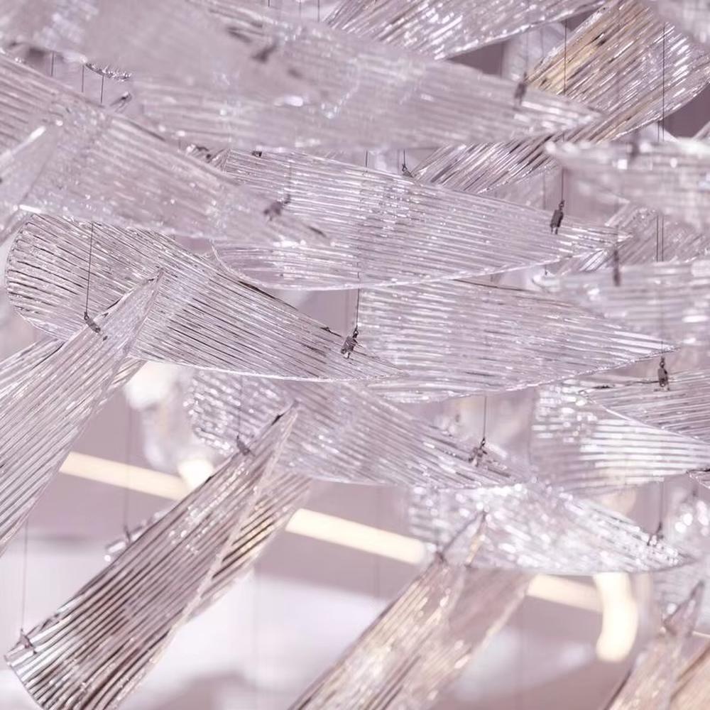 This is a large artistic crystal chandelier, composed of numerous irregular transparent sheet-like components. It has a layered, art-sculpture-like design and presents a luxurious and dreamy effect with purple lighting. It is used for decorating the space and providing lighting, with both artistic sense and practicality. It is suitable for high-end hotel lobbies, luxury casinos, large banquet halls and other high-end places.