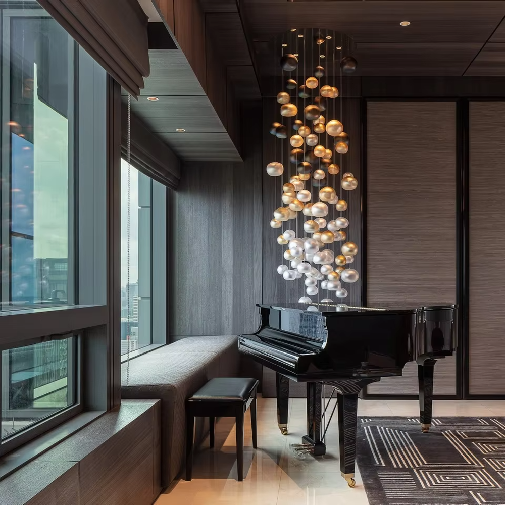 This artistic pendant chandelier consists of spherical lamp shades with a gradient from gold to silver, resembling flowing pearls or bubbles. It serves both lighting and decorative purposes, ideal for high-ceiling spaces, villa living rooms, art galleries, and high-end clubs.