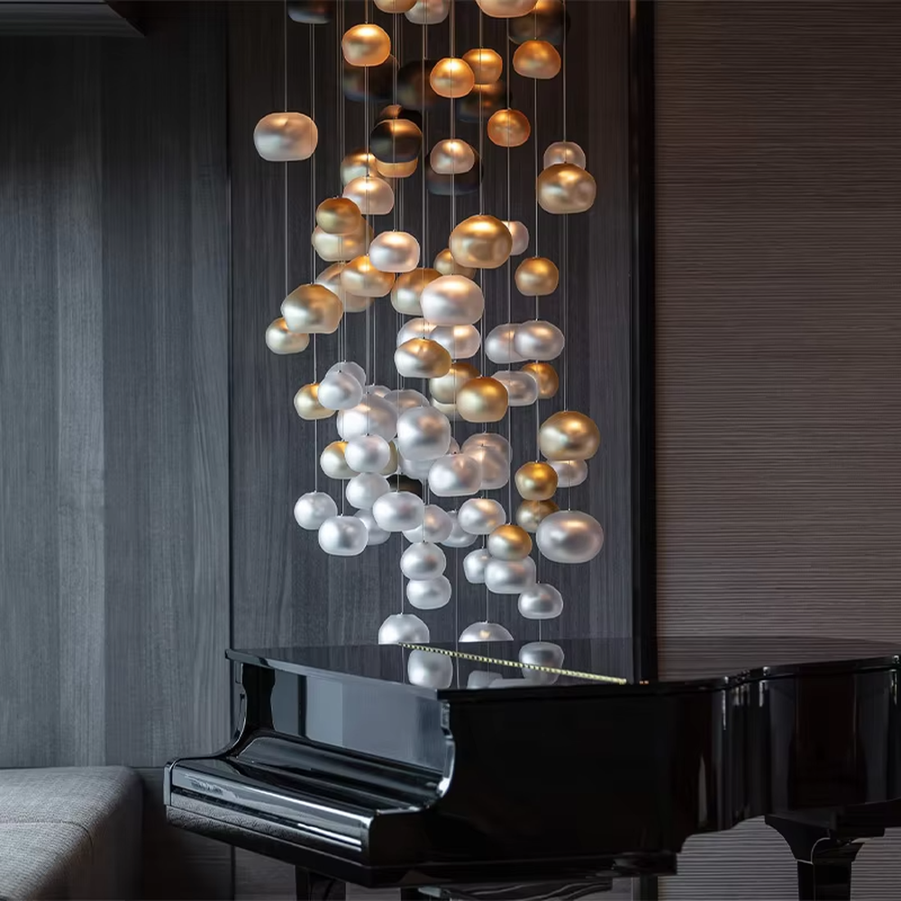 This artistic pendant chandelier consists of spherical lamp shades with a gradient from gold to silver, resembling flowing pearls or bubbles. It serves both lighting and decorative purposes, ideal for high-ceiling spaces, villa living rooms, art galleries, and high-end clubs.