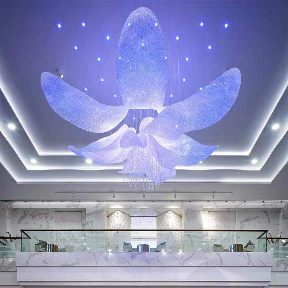This large-scale art chandelier features a blooming flower shape, with petal structures made of translucent crystal/acrylic material, paired with gradient blue-purple lighting and starry sky accents. It serves both lighting and artistic decorative purposes, ideal for high-ceiling commercial spaces such as hotel lobbies, sales offices, and high-end clubs.