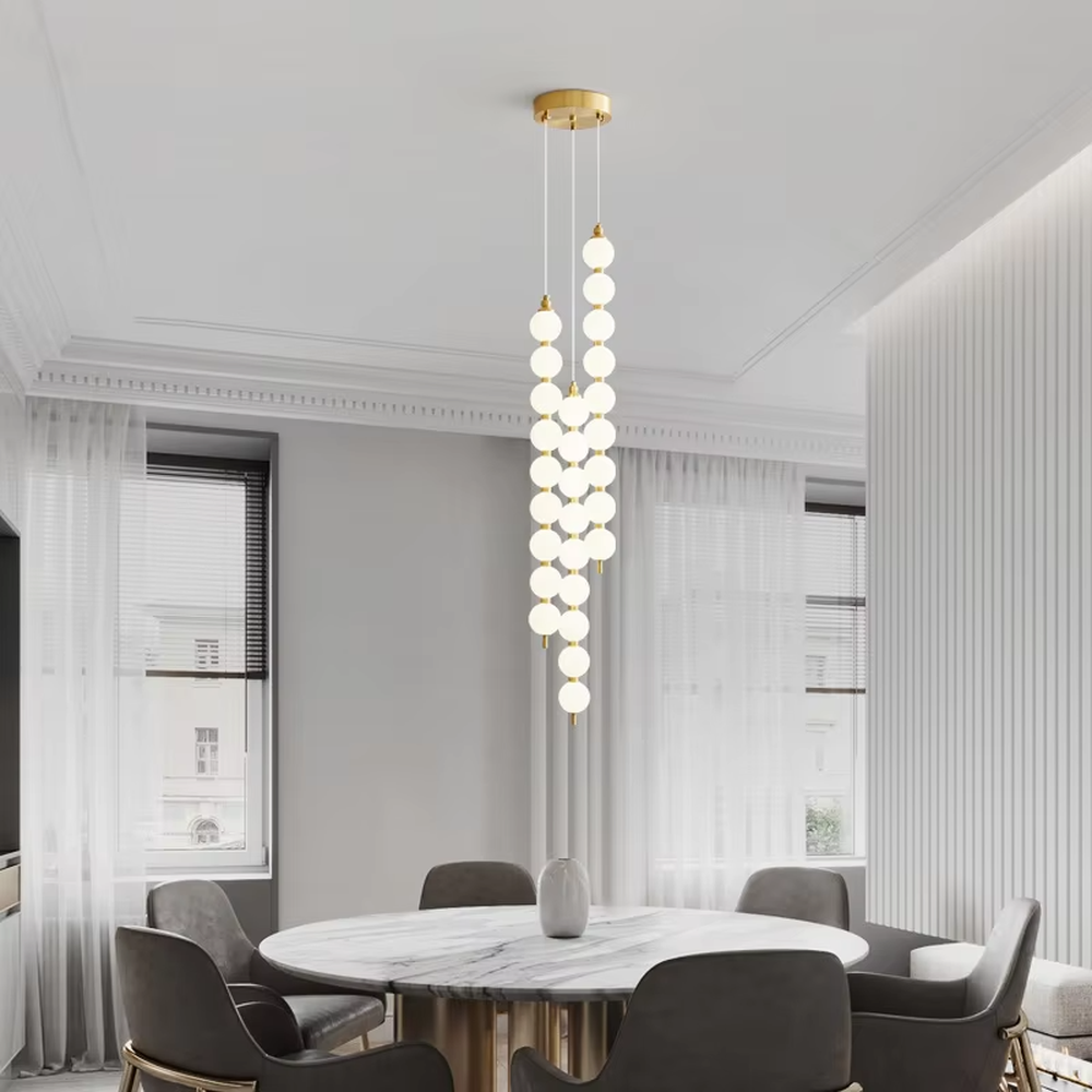 Modern light luxury double-strip spherical cascading chandelier, with a gold metal top plate paired with two strips of milky white luminous bulbs hanging staggered, emitting soft and even light, combining decorativeness and practicality, suitable for core lighting and atmosphere creation in spaces such as dining rooms, high-ceiling living rooms, and duplex stairs.