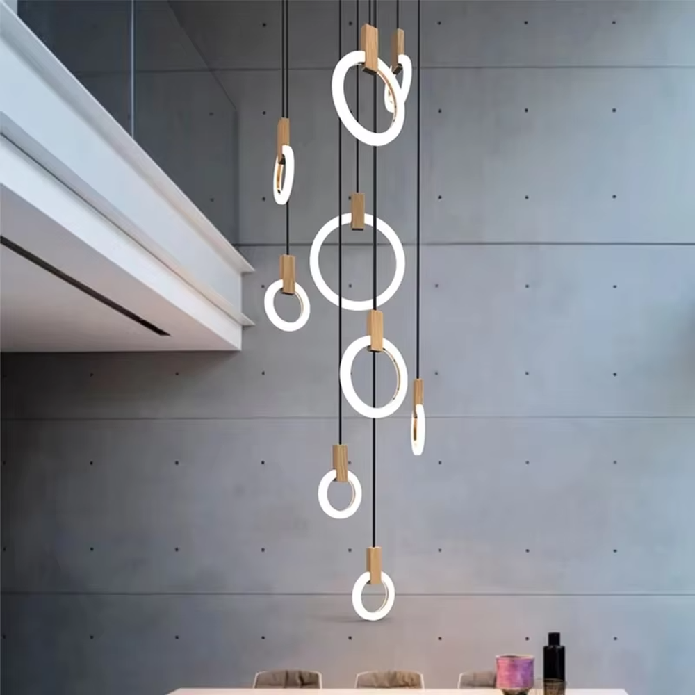 Modern light luxury multi-layer ring LED chandelier, composed of luminous rings of varying sizes and gold metal top bases, hanging in a staggered manner to present a flowing rhythmic sense. It emits soft and even light, combining decorativeness and lighting function, suitable for main lighting and atmosphere creation in high-ceiling spaces such as duplex stairs, high-ceiling living rooms, and villas.