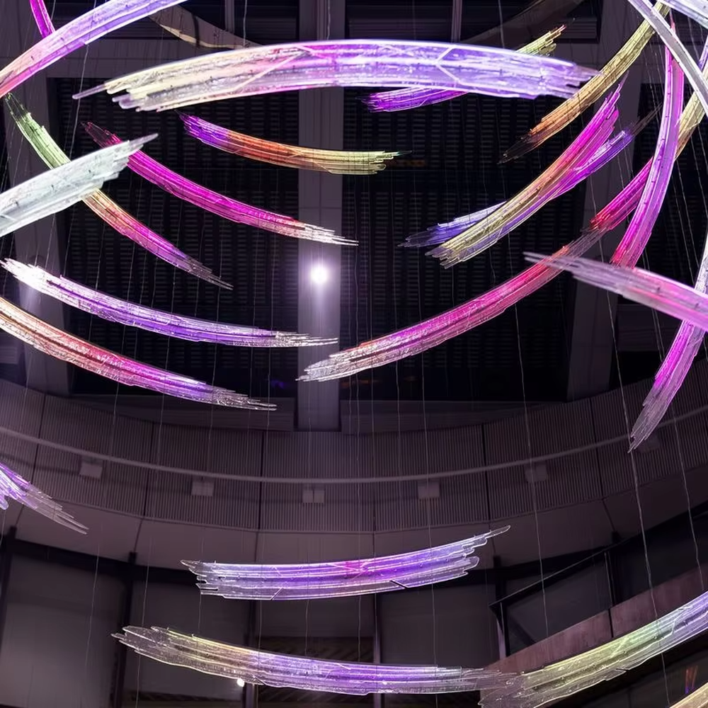 Art gradient spiral LED chandelier (color light stripes + ring structure), colorful warm light effect, creating a futuristic artistic atmosphere for high-end space decoration.