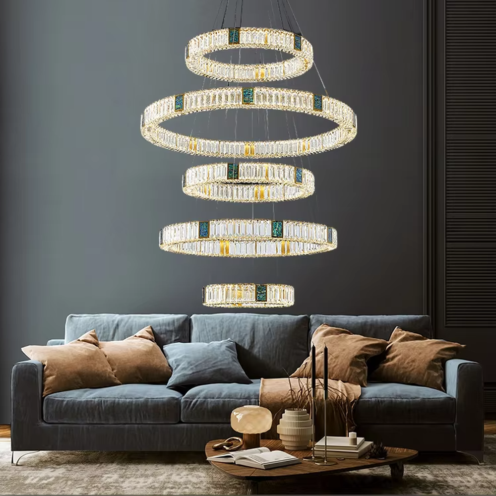 This is a light luxury artistic spiral crystal chandelier, featuring multi-layered circular crystal strips paired with a gold metal frame and emerald accents, shaped like a flowing tornado. Light refracts through the crystals to create brilliant and luxurious lighting effects, serving both lighting and artistic decoration purposes, suitable for high-ceiling spaces such as villa high-ceiling living rooms, duplex voids, hotel lobbies, and high-end clubs.