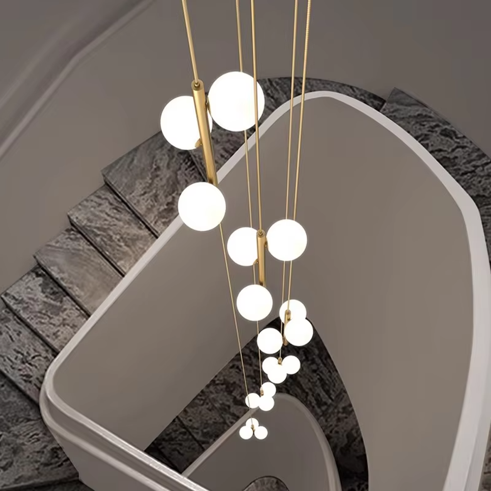 Nordic light luxury style staggered spherical chandelier, with gold metal suspension rods paired with milky white luminous bulbs, arranged in a cascading staggered layout. It emits soft and warm light, combining decorativeness and lighting function, suitable for core lighting and atmosphere creation in high-ceiling spaces such as duplex stairs, high-ceiling living rooms, and villa hollow areas.
