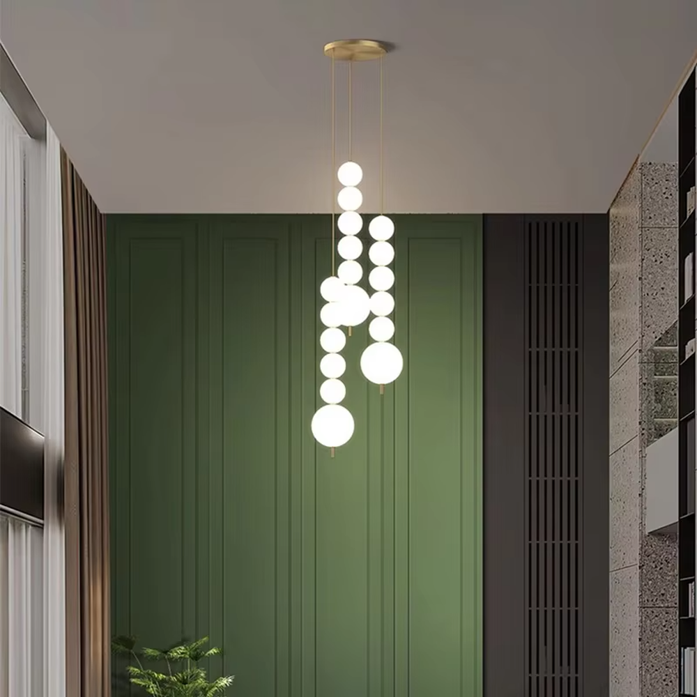 Modern light luxury double-strip spherical cascading chandelier, with a gold metal top plate paired with two strips of milky white luminous bulbs hanging staggered, emitting soft and even light, combining decorativeness and practicality, suitable for core lighting and atmosphere creation in spaces such as dining rooms, high-ceiling living rooms, and duplex stairs.