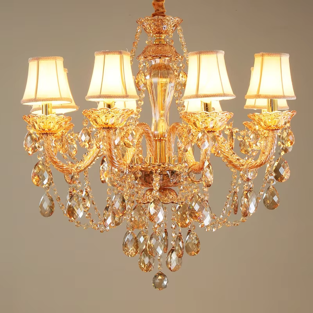 European-style luxury golden crystal chandelier, with amber multi-layer crystal pendants, off-white fabric lampshades and gold carved metal frames, providing warm and brilliant light, designed to enhance the luxurious atmosphere of spaces, suitable for high-end scenarios such as villa living rooms, hotel lobbies, and banquet halls