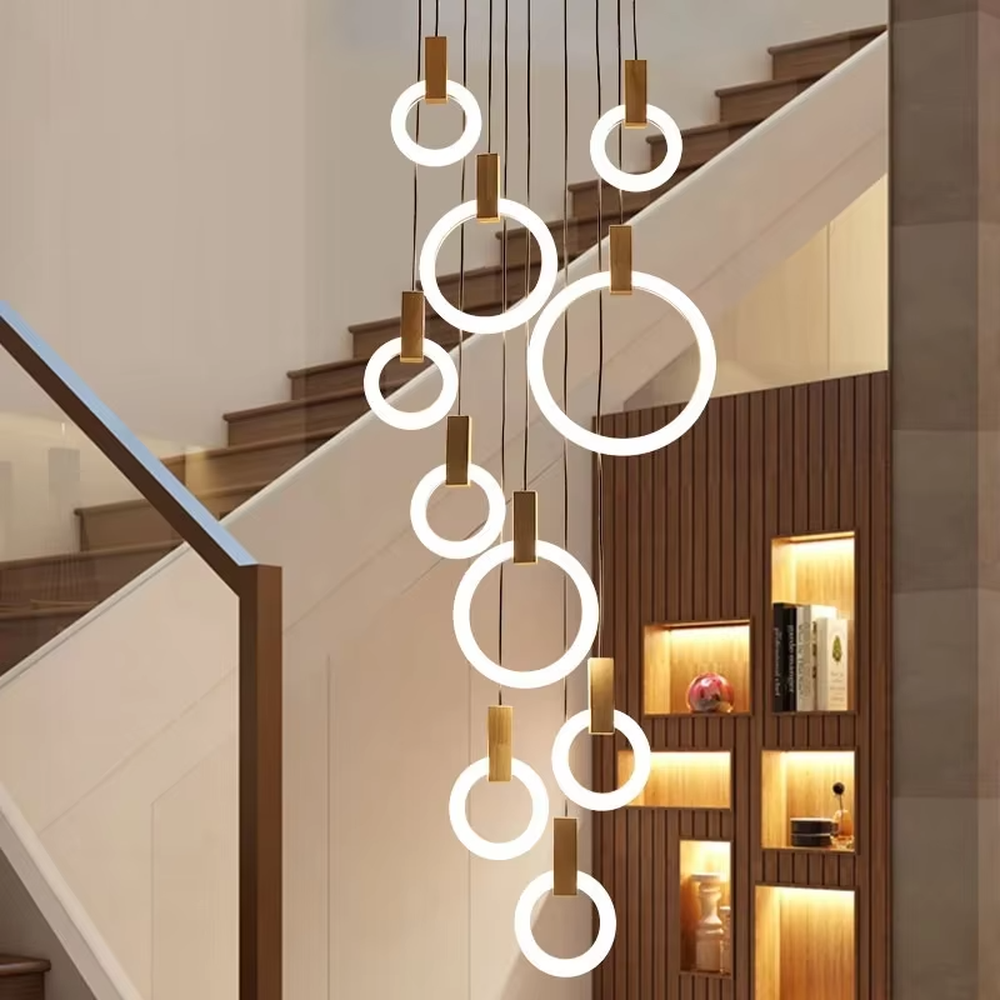 Modern light luxury multi-layer ring LED chandelier, composed of luminous rings of varying sizes and gold metal top bases, hanging in a staggered manner to present a flowing rhythmic sense. It emits soft and even light, combining decorativeness and lighting function, suitable for main lighting and atmosphere creation in high-ceiling spaces such as duplex stairs, high-ceiling living rooms, and villas.