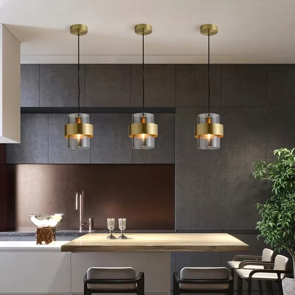 Light luxury gold ring glass triple chandelier (transparent glass lampshade + gold metal ring + black hanging wire with gold base), warm light effect, creating a modern and high-end kitchen and dining space atmosphere.