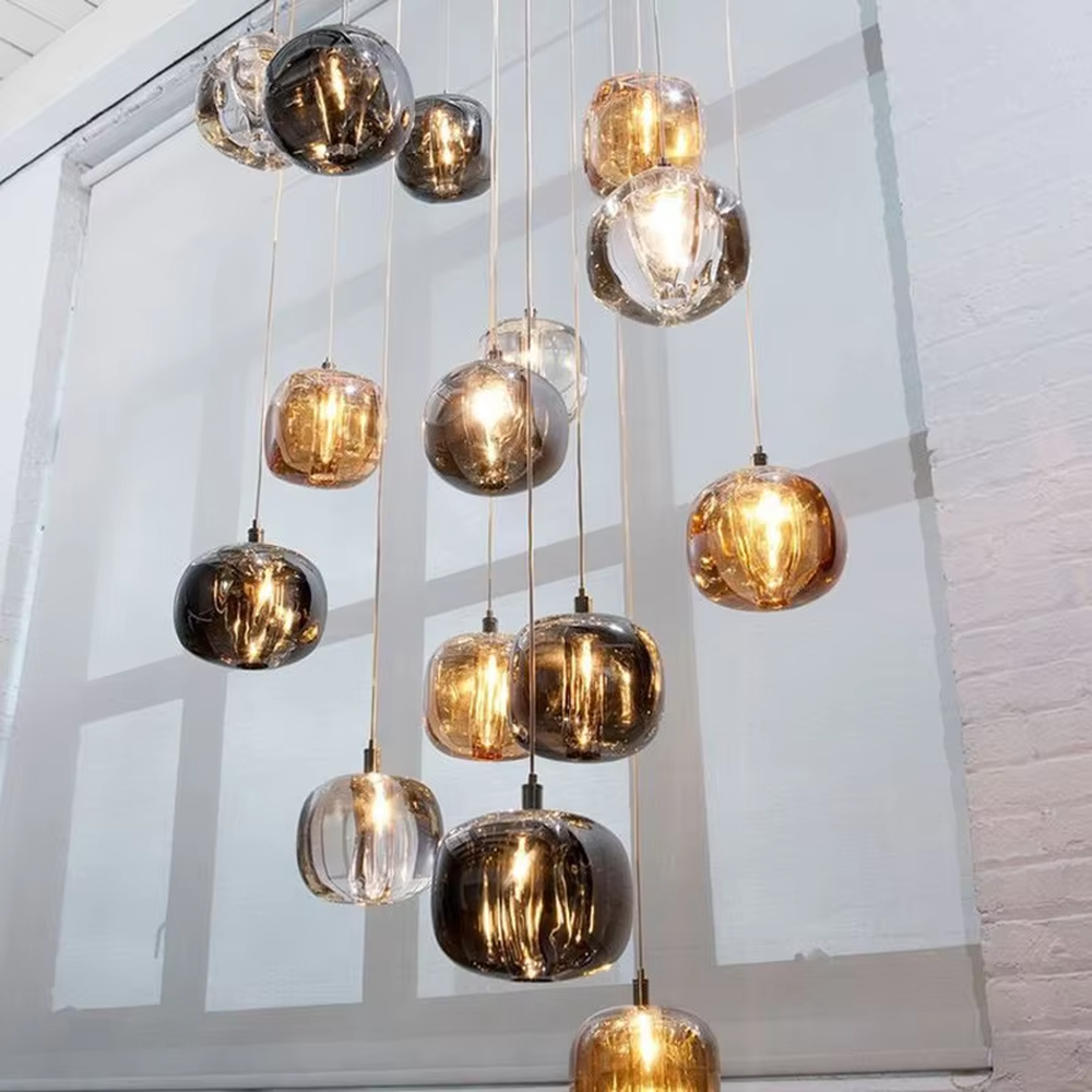 Modern minimalist gradient glass square ball chandelier (gray/gold/transparent combination), warm light effect, creating a high-quality minimalist space atmosphere.