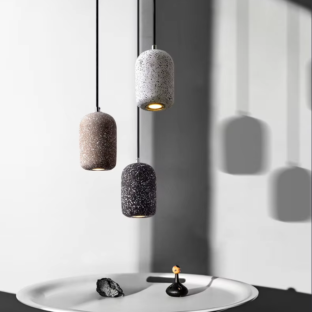 Industrial style speckled cement cylinder multi-head pendant light (multi-color), warm light effect, creating a minimalist industrial style atmosphere.