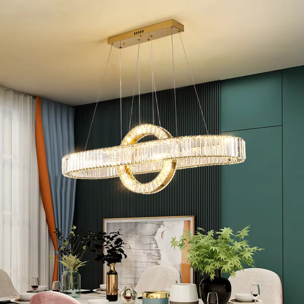 This is a light luxury and luxurious long strip ring crystal chandelier, with a golden metal frame paired with transparent crystals, adopting a combination of long strip and ring shape. When lit, the light is brilliant and gorgeous, creating a high-end light luxury atmosphere.