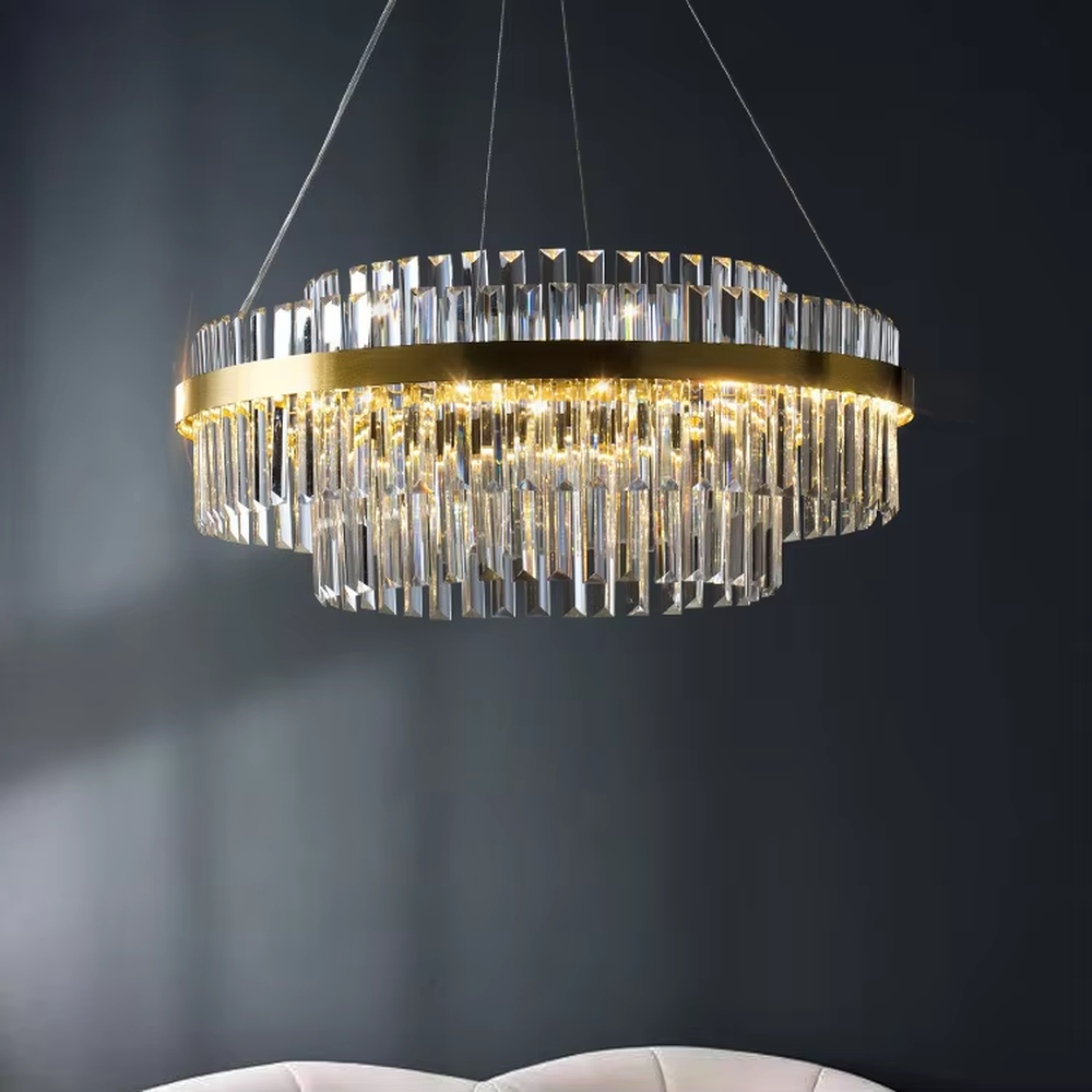 This is a light luxury style multi-layer circular crystal chandelier, featuring a gold metal frame paired with transparent cut crystal strips. The light refracts through the crystals to create a brilliant and luxurious lighting effect, serving both lighting and decorative purposes, and is suitable for quality-focused scenarios such as villa living rooms, duplex high-ceiling spaces, hotel lobbies, and high-end restaurants.