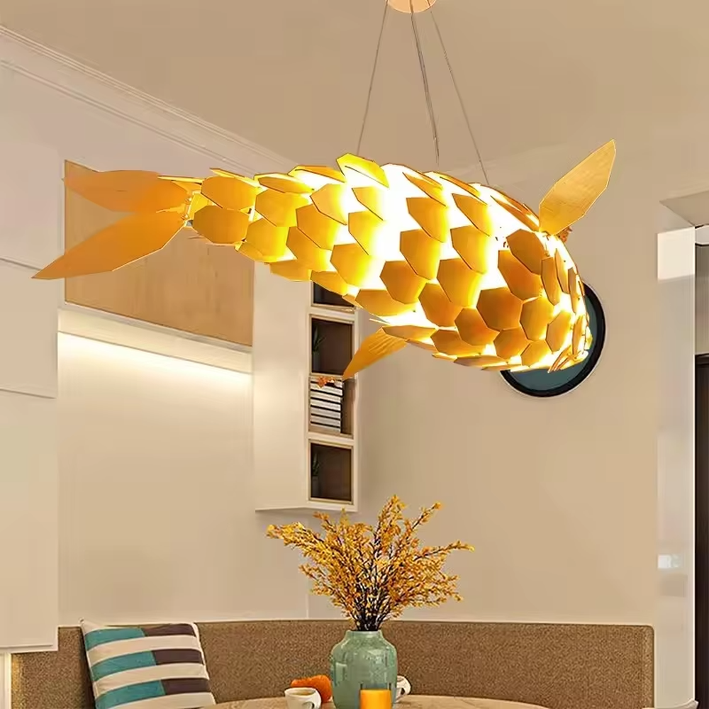 This is an artistic golden fish-shaped chandelier with a golden scale structure in the shape of a fish, featuring a flexible and artistic design. It is used for space lighting and decoration, creating an artistic luxury atmosphere. It is suitable for new Chinese-style home living rooms, creative restaurants, art soft decoration spaces and other places.