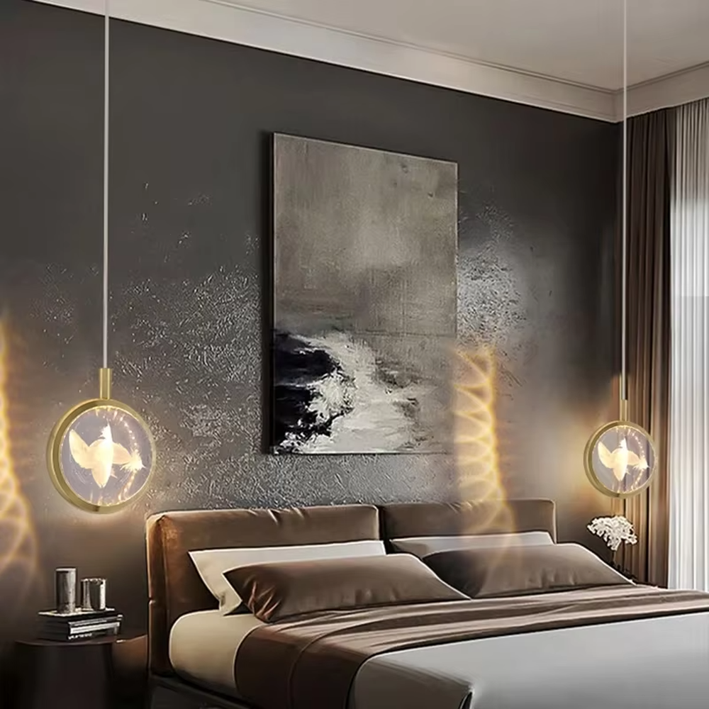 This light luxury small round chandelier features a gold metal frame, a transparent panel with delicate patterns such as jellyfish/birds, and projects ripple light and shadow on the wall when lit, serving both lighting and decorative purposes, ideal for bedroom bedside tables, light luxury homestays, high-end hotel rooms and other spaces.