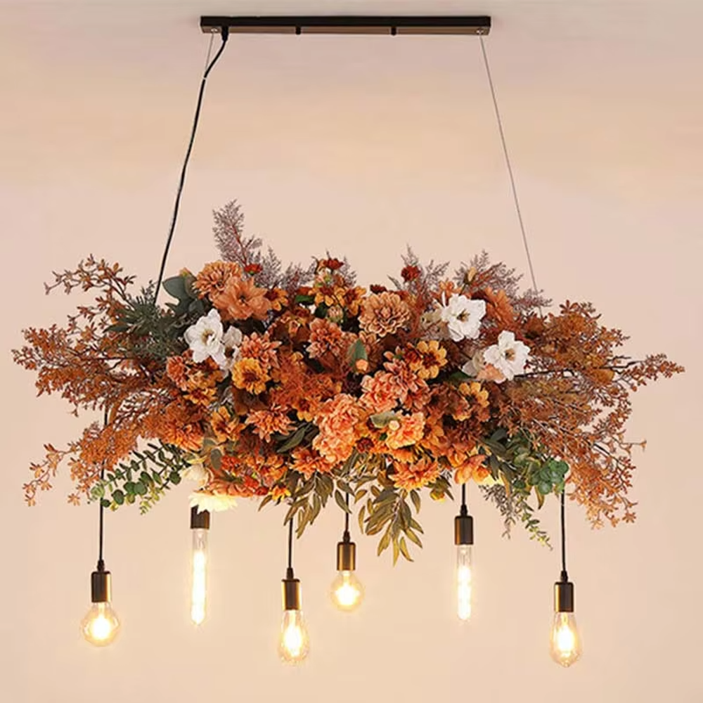 This is a romantic natural-style long strip floral retro chandelier, with blue and white artificial flowers (hydrangeas, orchids, etc.) and green plants as the main decoration, paired with retro bulbs. It has a fresh and romantic style, with warm and soft lighting.