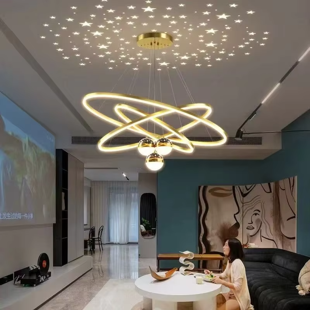 This modern light luxury galaxy-shaped chandelier features multi-layer interlaced ring light strips made of gold metal, paired with spherical crystal lamp shades, and has a built-in starry sky projection effect on the top. It serves both lighting and decorative purposes, ideal for modern home spaces such as living rooms and dining rooms, as well as light luxury commercial venues.
