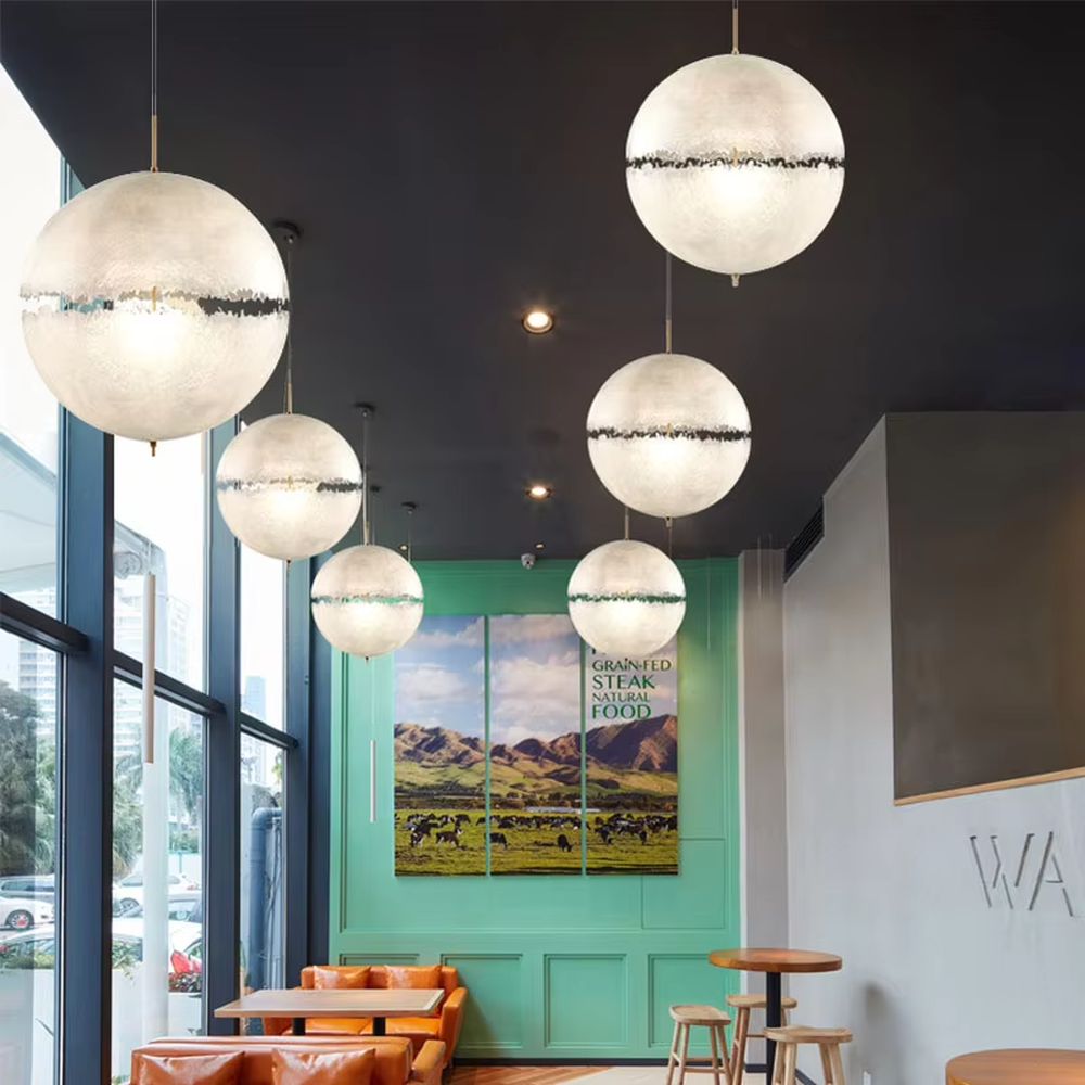 Modern art-style multi-head frosted spherical chandelier, water-textured white shade + black-gold decoration + warm light effect, creating a fresh artistic atmosphere in public spaces.