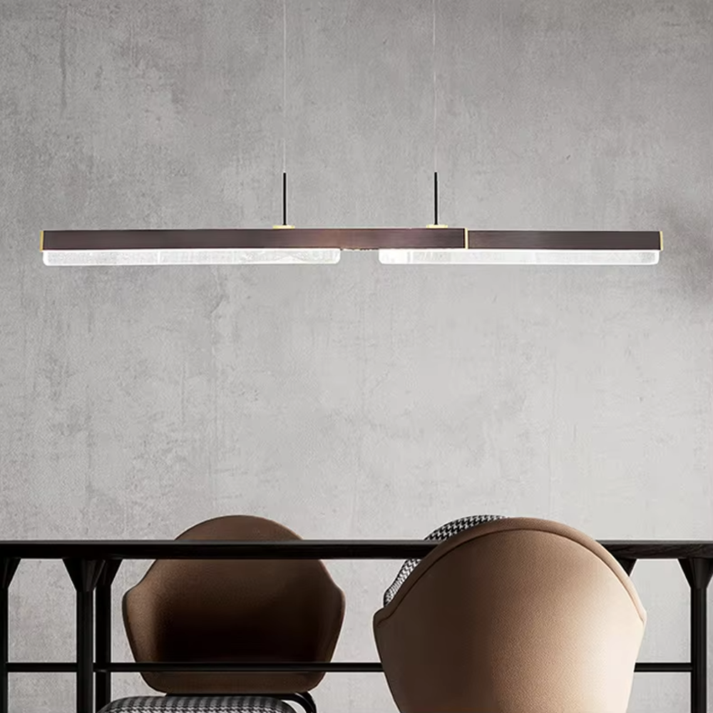 This is a modern minimalist style linear chandelier, featuring a walnut texture panel paired with brass metal accents. The linear lighting design emits soft and uniform light, serving both practical lighting and space decoration purposes, suitable for dining rooms, open kitchens, light luxury bars, modern office areas and other scenarios.