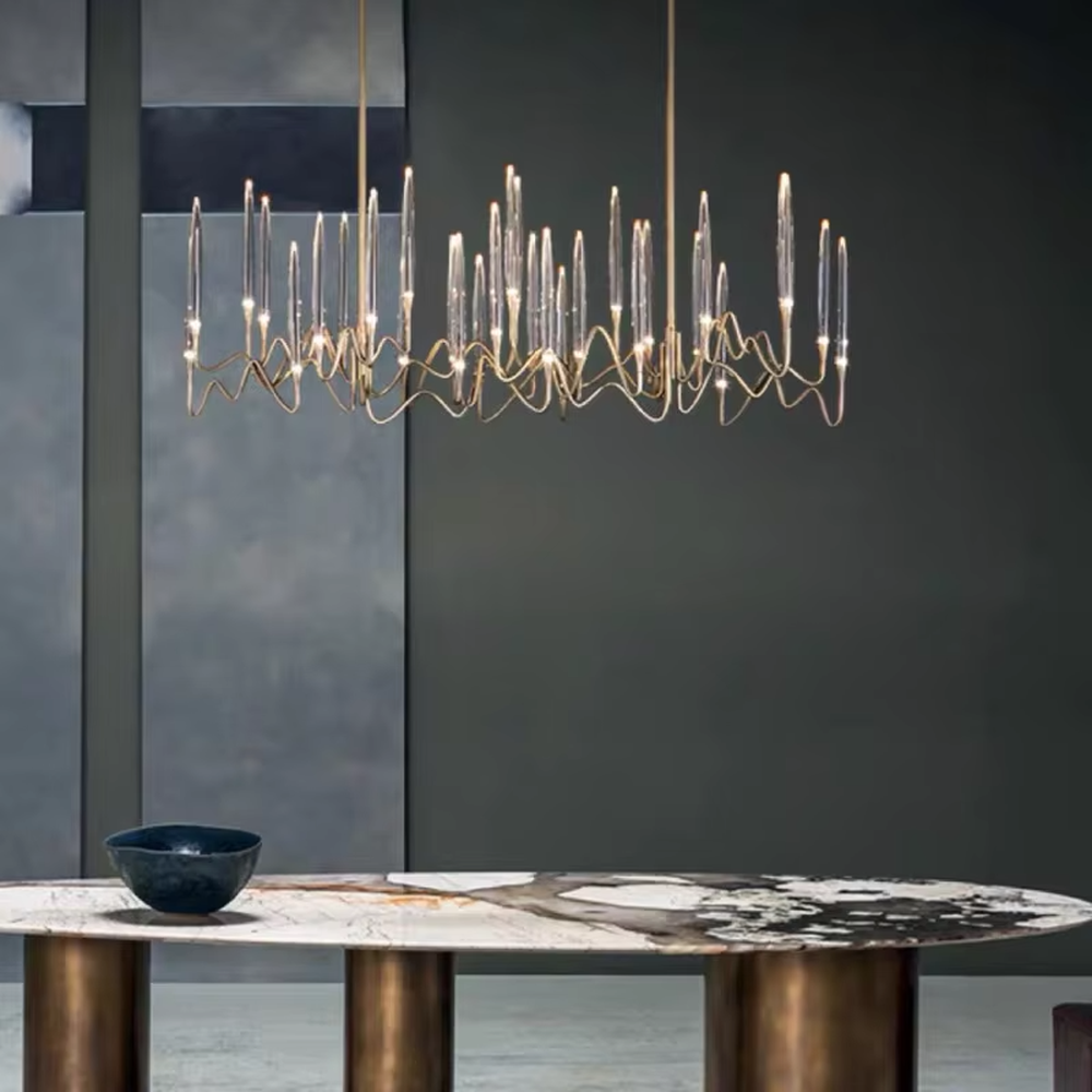This is a modern artistic luxury chandelier, with a golden metal curved frame and transparent glass tube - shaped lampshades, featuring artistic layers and strong luxury sense. It is used for space lighting and decoration, creating an artistic luxury atmosphere. It is suitable for high - end restaurants, modern luxury home living rooms, art soft decoration spaces and other places.