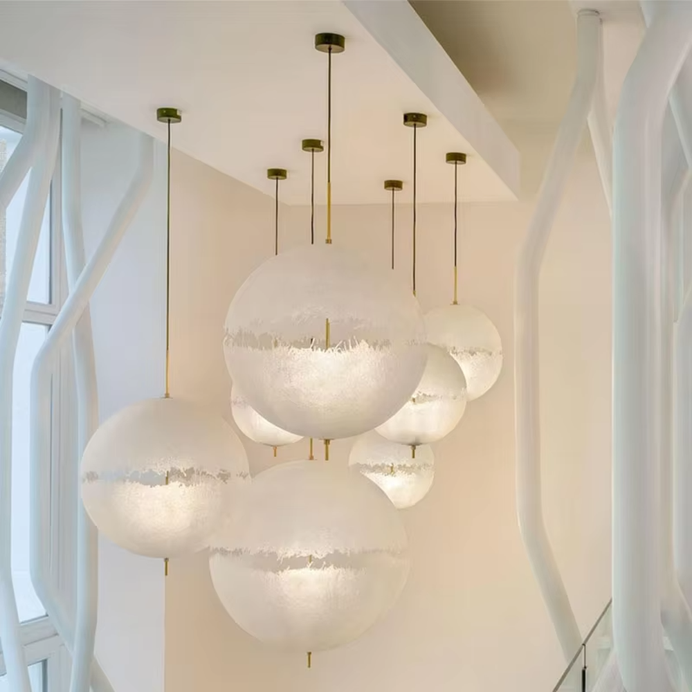 Modern art-style multi-head frosted spherical chandelier, water-textured white shade + black-gold decoration + warm light effect, creating a fresh artistic atmosphere in public spaces.