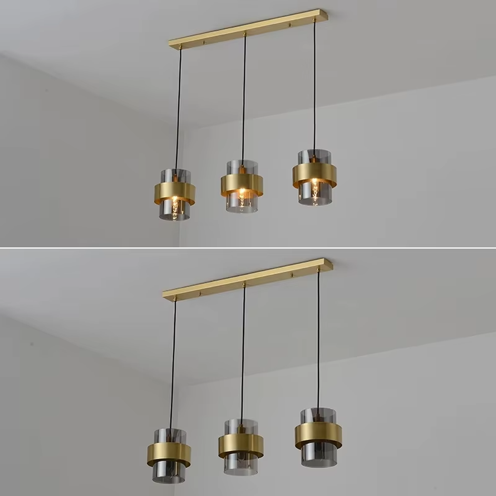 Light luxury gold ring glass triple chandelier (transparent glass lampshade + gold metal ring + black hanging wire with gold base), warm light effect, creating a modern and high-end kitchen and dining space atmosphere.