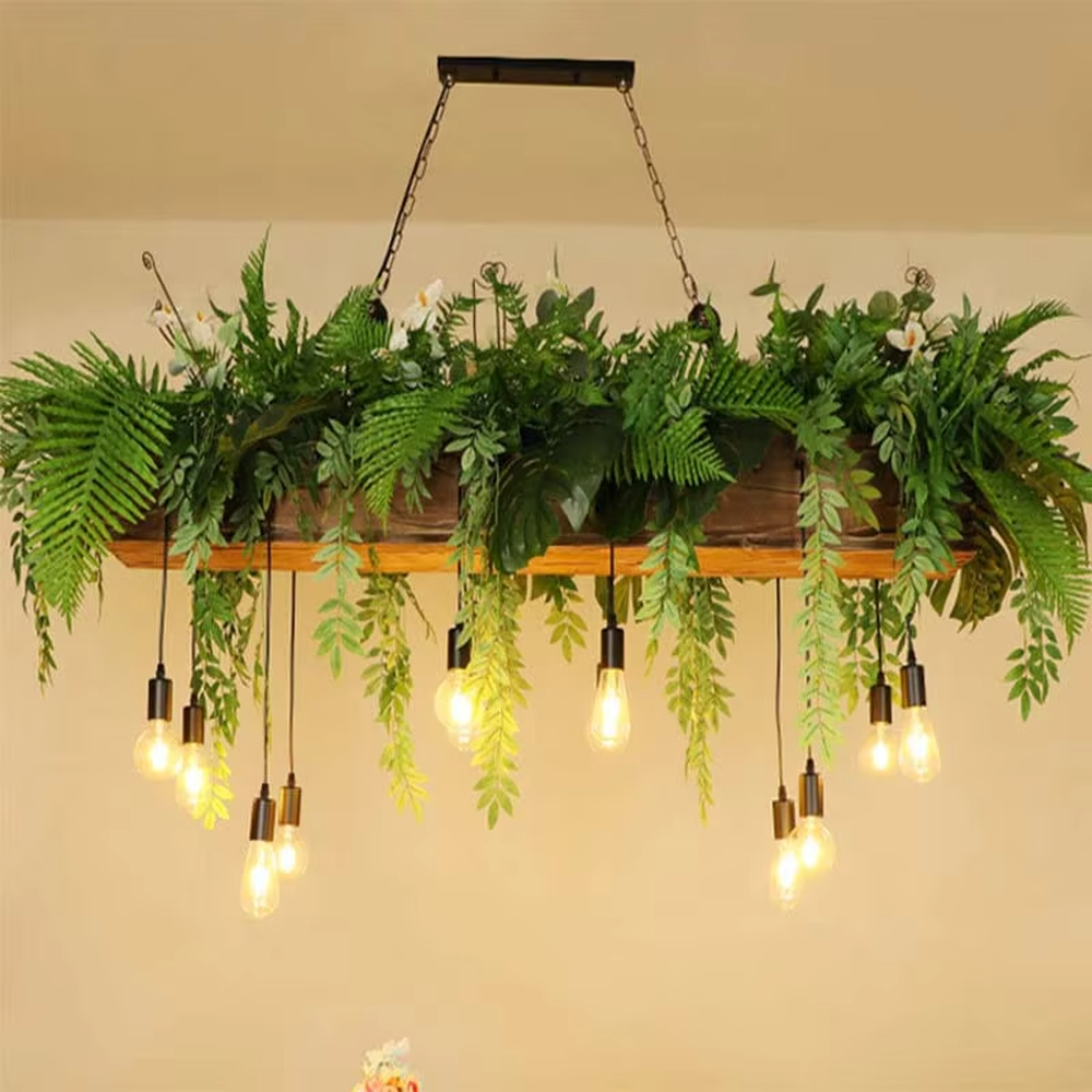 This is a romantic natural-style long strip floral retro chandelier, with blue and white artificial flowers (hydrangeas, orchids, etc.) and green plants as the main decoration, paired with retro bulbs. It has a fresh and romantic style, with warm and soft lighting.