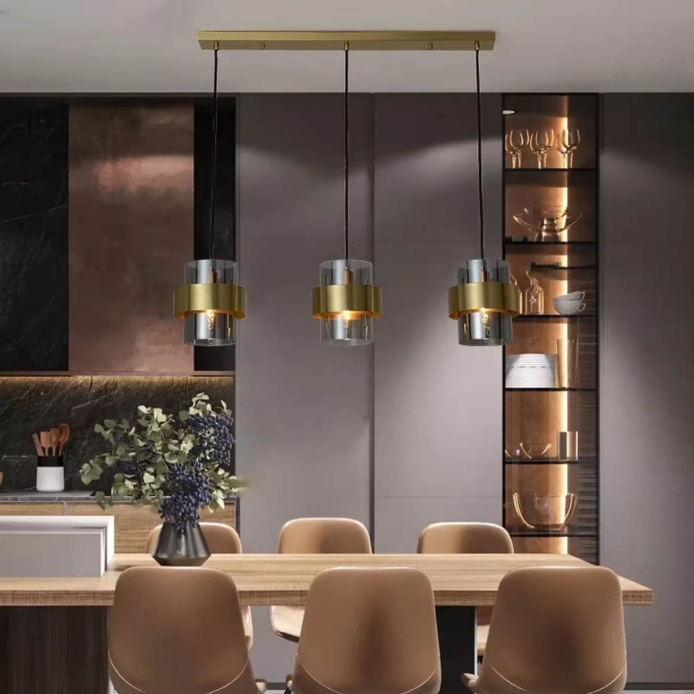 Light luxury gold ring glass triple chandelier (transparent glass lampshade + gold metal ring + black hanging wire with gold base), warm light effect, creating a modern and high-end kitchen and dining space atmosphere.
