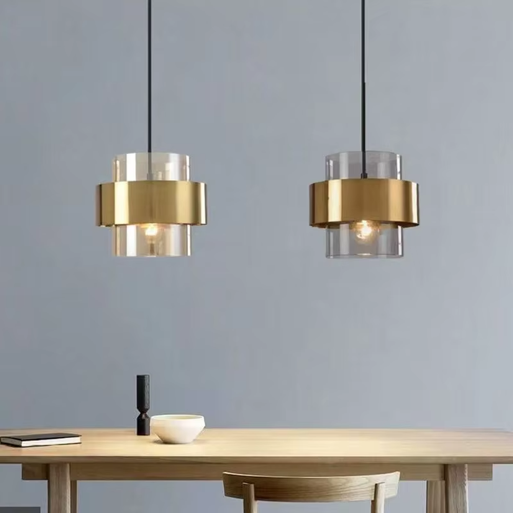 Light luxury gold ring glass triple chandelier (transparent glass lampshade + gold metal ring + black hanging wire with gold base), warm light effect, creating a modern and high-end kitchen and dining space atmosphere.